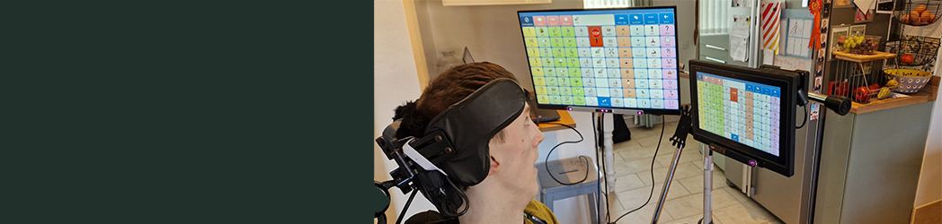 A person looking at two eye gaze controlled screens