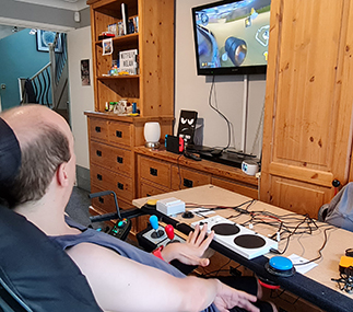 Person playing a console game using accessible controller