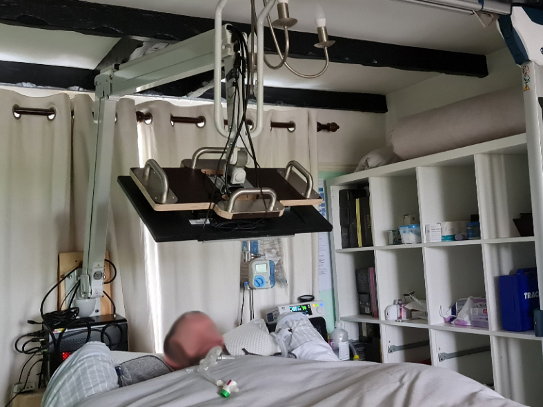 A computer monitor suspended a person lying on a bed